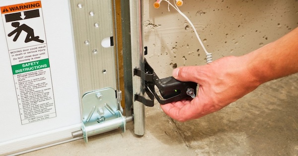 image of man setting garage door sensors in place