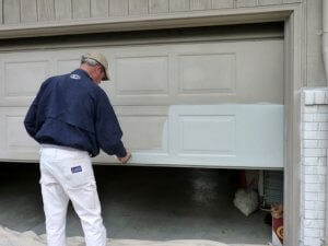 man painting garage door